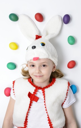 Girl in a bunny suit with Easter eggs on a white backgroundの写真素材