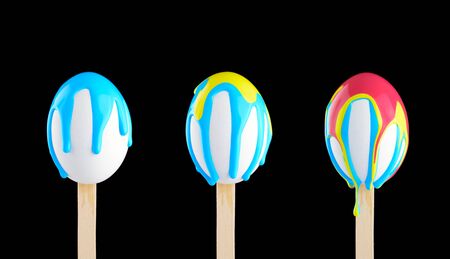 White eggs on a wooden stick doused with paintの写真素材