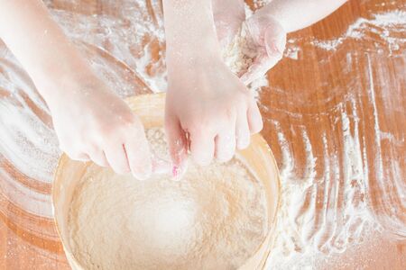 Children's hands on the flour on the table