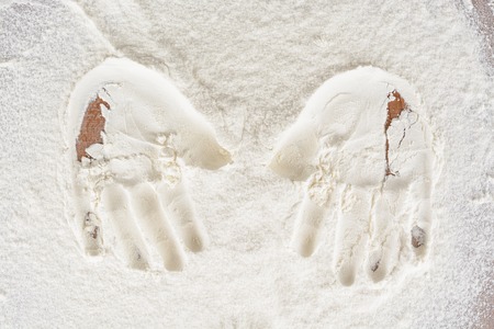 Traces of children's hands on the flour on the tableの写真素材