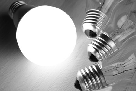 Glowing LED lamp including incandescent lamps on a wooden table