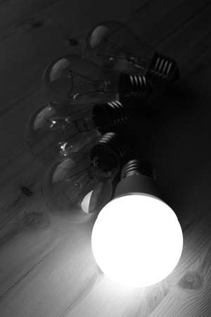 Glowing LED lamp including incandescent lamps on a wooden tableの写真素材