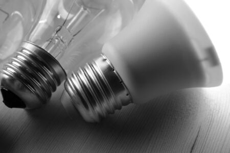 Glowing LED lamp including incandescent lamps on a wooden table, black and white photographyの写真素材