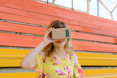 Young woman having fun with virtual reality glasses at the city stadiumの写真素材