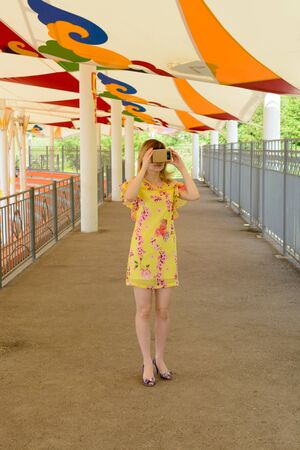 Young woman having fun with virtual reality glasses at the city stadiumの写真素材