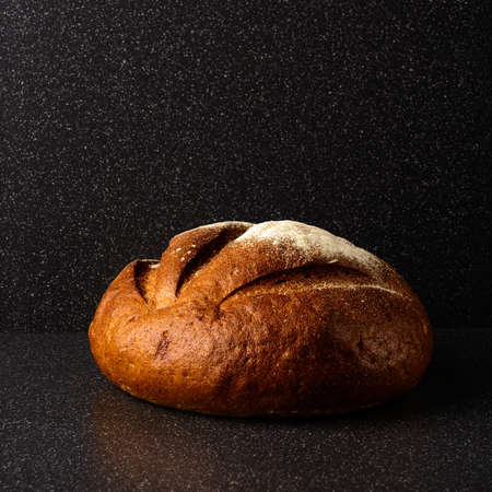 A loaf of rye bread on a dark backgroundの写真素材