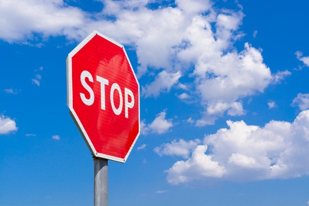 Road stop sign on a background of clouds
