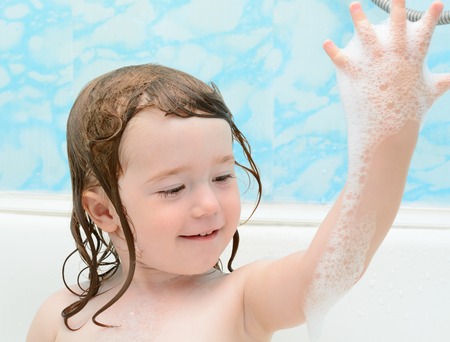 Little girl playing and laughing in the bathroom
