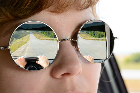 Reflection suburban road in sun glasses womenの写真素材