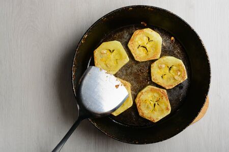 Fried courgette in the old frying pan on a wooden tableの写真素材