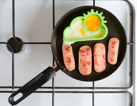 Fried eggs with sausages in a panの写真素材