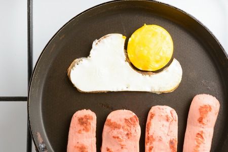 Fried eggs with sausages in a panの写真素材