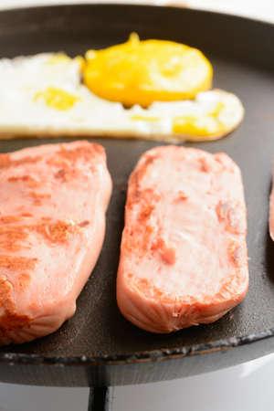 Fried eggs with sausages in a panの写真素材
