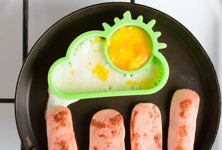 Fried eggs with sausages in a panの写真素材