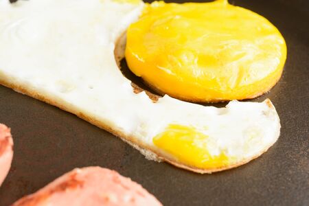 Fried eggs with sausages in a panの写真素材