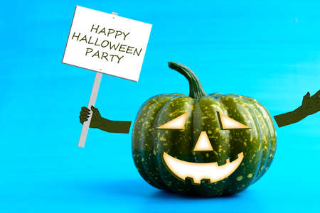 Halloween pumpkin with a poster in his hand on a blue backgroundの写真素材