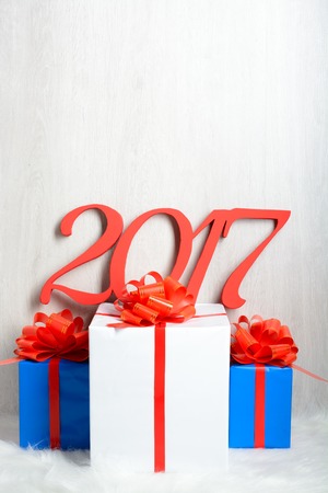 Number 2017 and Christmas gifts on a white carpet from fur