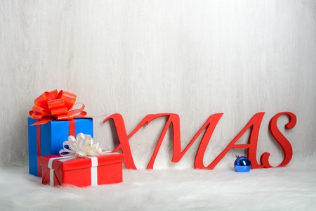 Word XMAS and Christmas gifts on a white carpet from furの写真素材