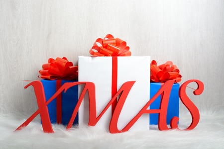 Word XMAS and Christmas gifts on a white carpet from furの写真素材