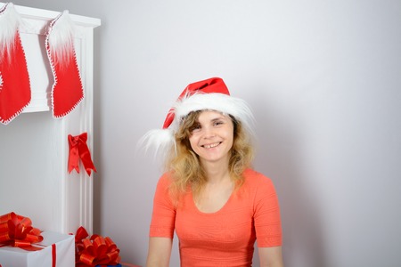 The girl in the orange dress is sitting on a Christmas fireplaceの写真素材