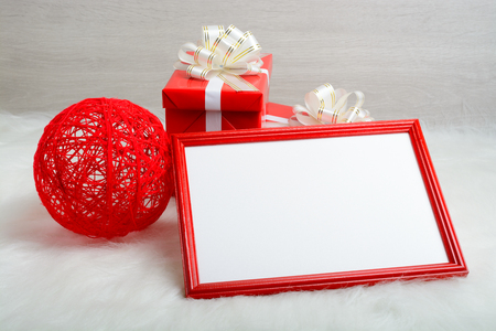 Red frame, gift box and a ball on a fur rugの写真素材