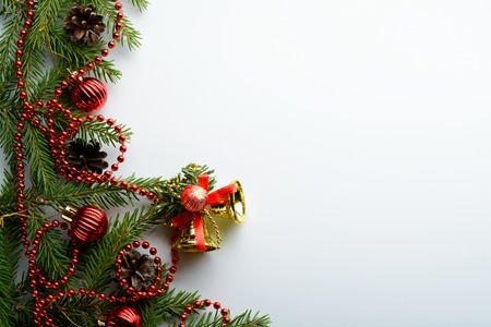 Spruce branches, red beads and bells on a white backgroundの写真素材
