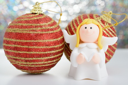 Toy angel with a book in his hand and two New Year's ballの写真素材