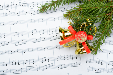 Christmas decorations and fir branch lying on notes sheetの写真素材