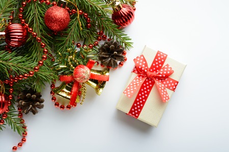 Christmas decoration with golden bell, gift, pine cone and branchの写真素材