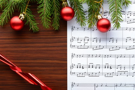 Christmas decorations and fir branch lying on notes sheetの写真素材