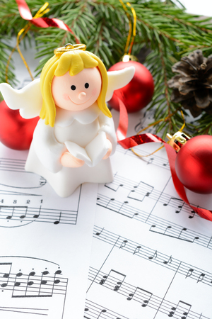 Christmas decorations and fir branch lying on notes sheetの写真素材