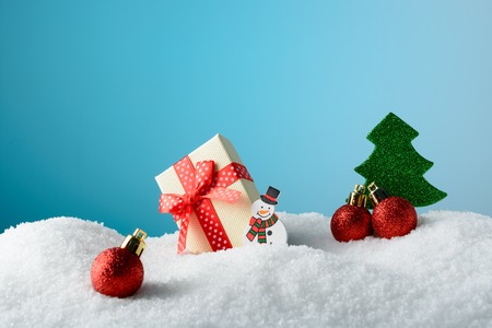 Christmas decoration snowman, Christmas tree and gift box on snowの写真素材