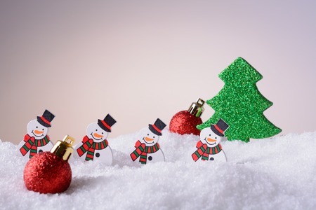 Christmas ornament snowmen, Christmas tree and red balls on snowの写真素材