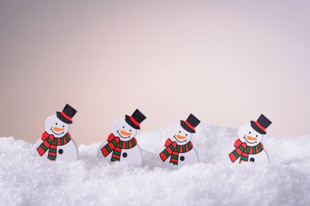 Four cheerful snowman with a hat in the snowの写真素材