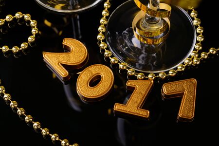 Two glasses of champagne and New Year decorations from 2017