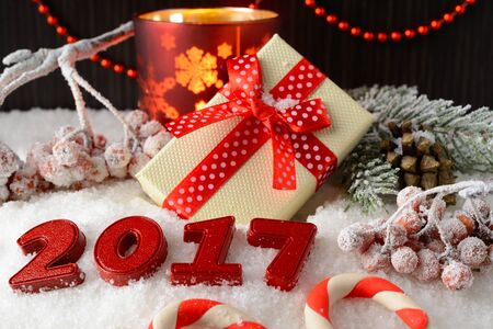Box with a gift and New Year decorations on white snowの写真素材