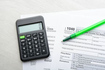 The tax return form with pen and calculator