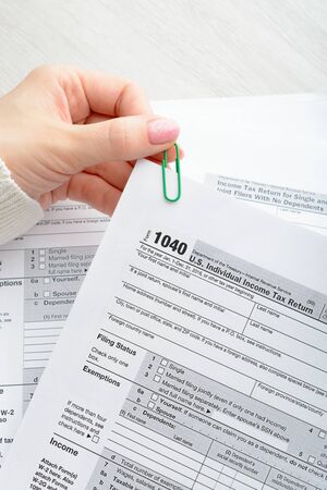 A woman sitting at a table and holds a tax formの写真素材