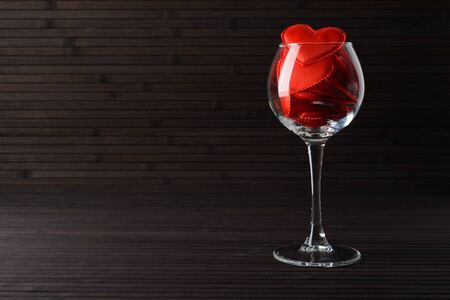 Red hearts in a glass on a table made of bambooの写真素材