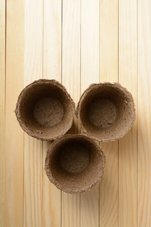 Peat pots for seedlings on a wooden backgroundの写真素材