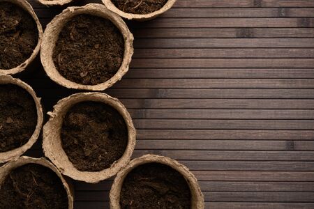 Peat pots with soil on a wooden tableの写真素材