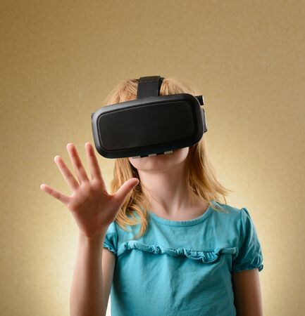 Little girl playing in virtual goggles indoorsの写真素材
