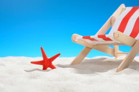 Red starfish near a lounger on the beach: closeupの写真素材