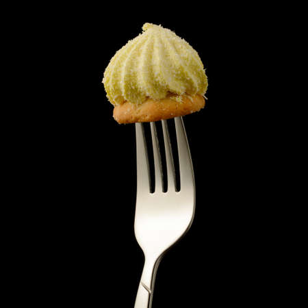 Pastry sprinkled with coconut chips on a metal fork