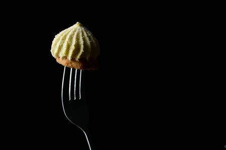 Pastry sprinkled with coconut chips on a metal forkの写真素材