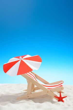 Deckchair on the beach on background of blue skyの写真素材