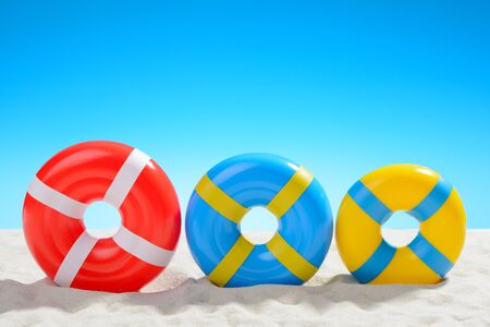 Swimming ring on the beach on background of blue skyの写真素材