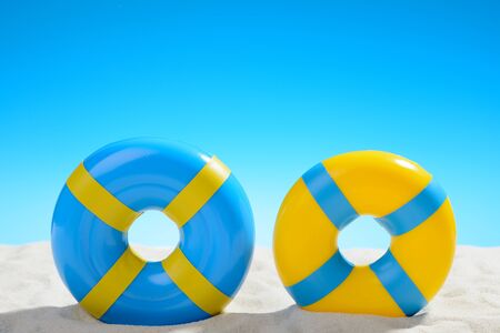 Swimming ring on the beach on background of blue skyの写真素材