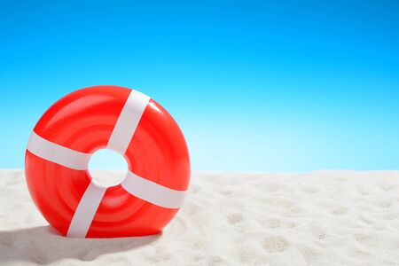 Swimming ring on the beach on background of blue skyの写真素材