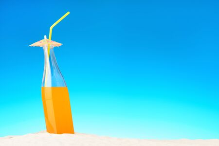 The bottle of orange juice on the beachの写真素材